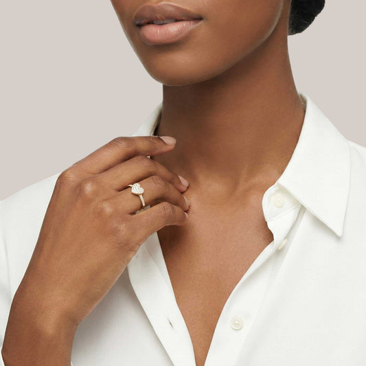 Woman wearing a white shirt and a ring on a neutral background