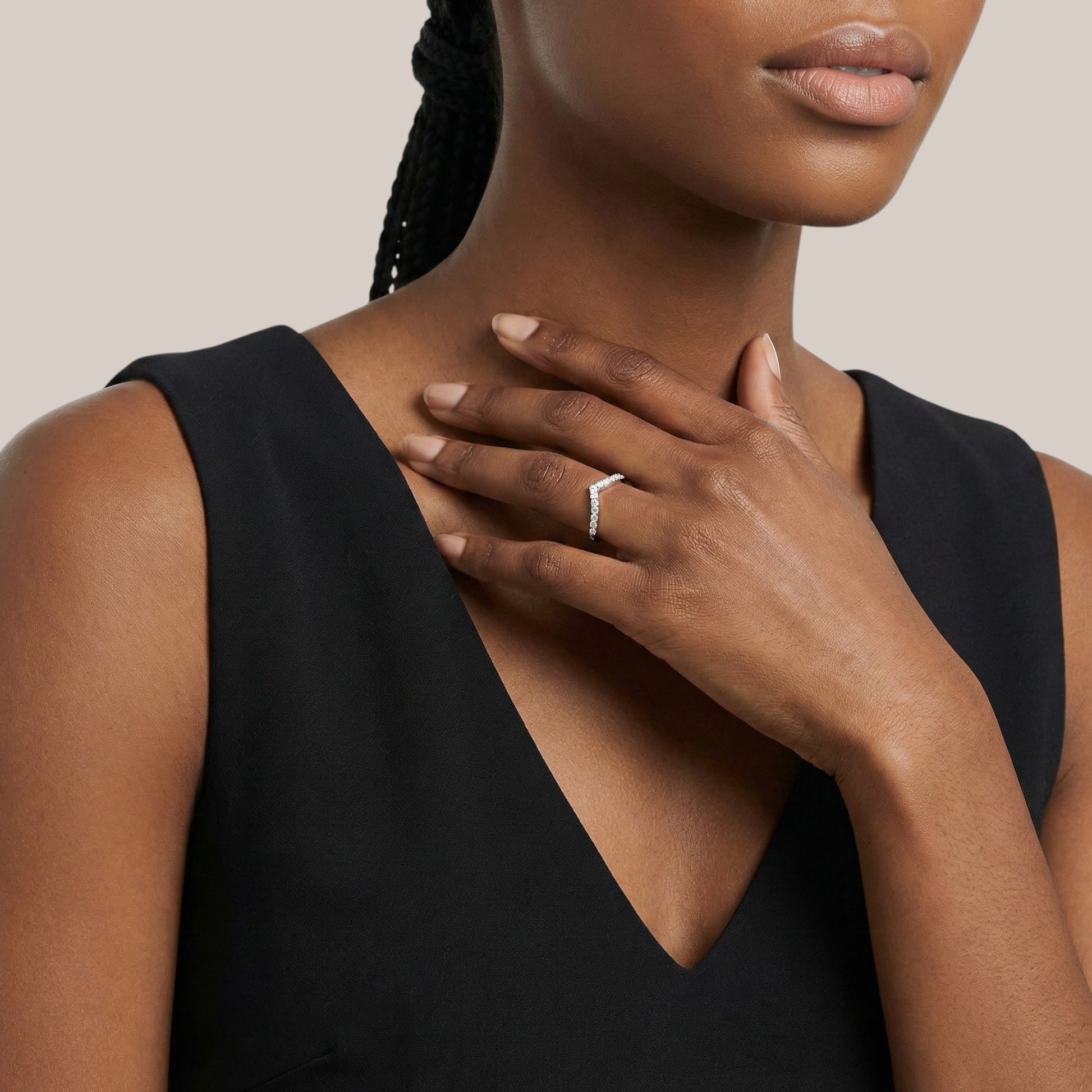 Woman wearing a black sleeveless top with a neutral background