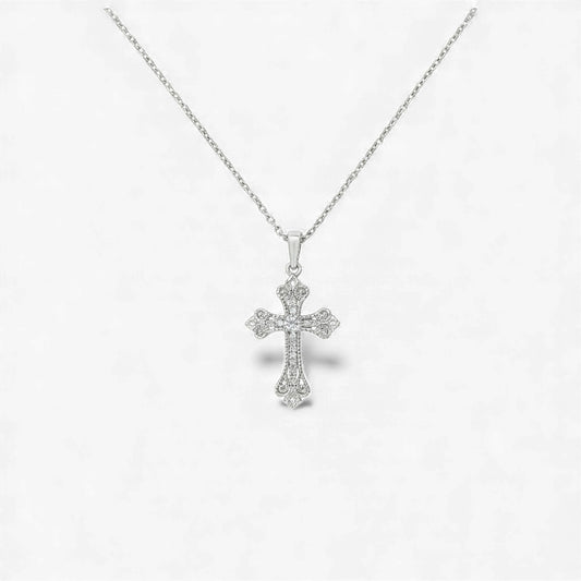 Silver cross pendant necklace on a light gray background