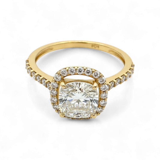 Gold ring with a large diamond and smaller diamonds on the band against a white background