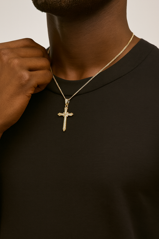 Person wearing a gold cross necklace on a plain background