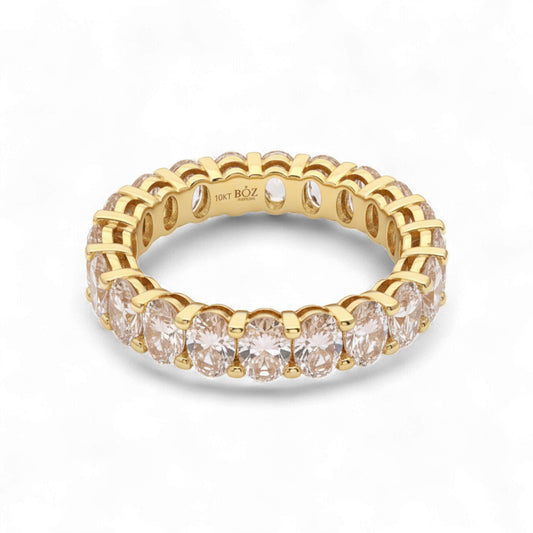 Gold ring with clear gemstones on a white background