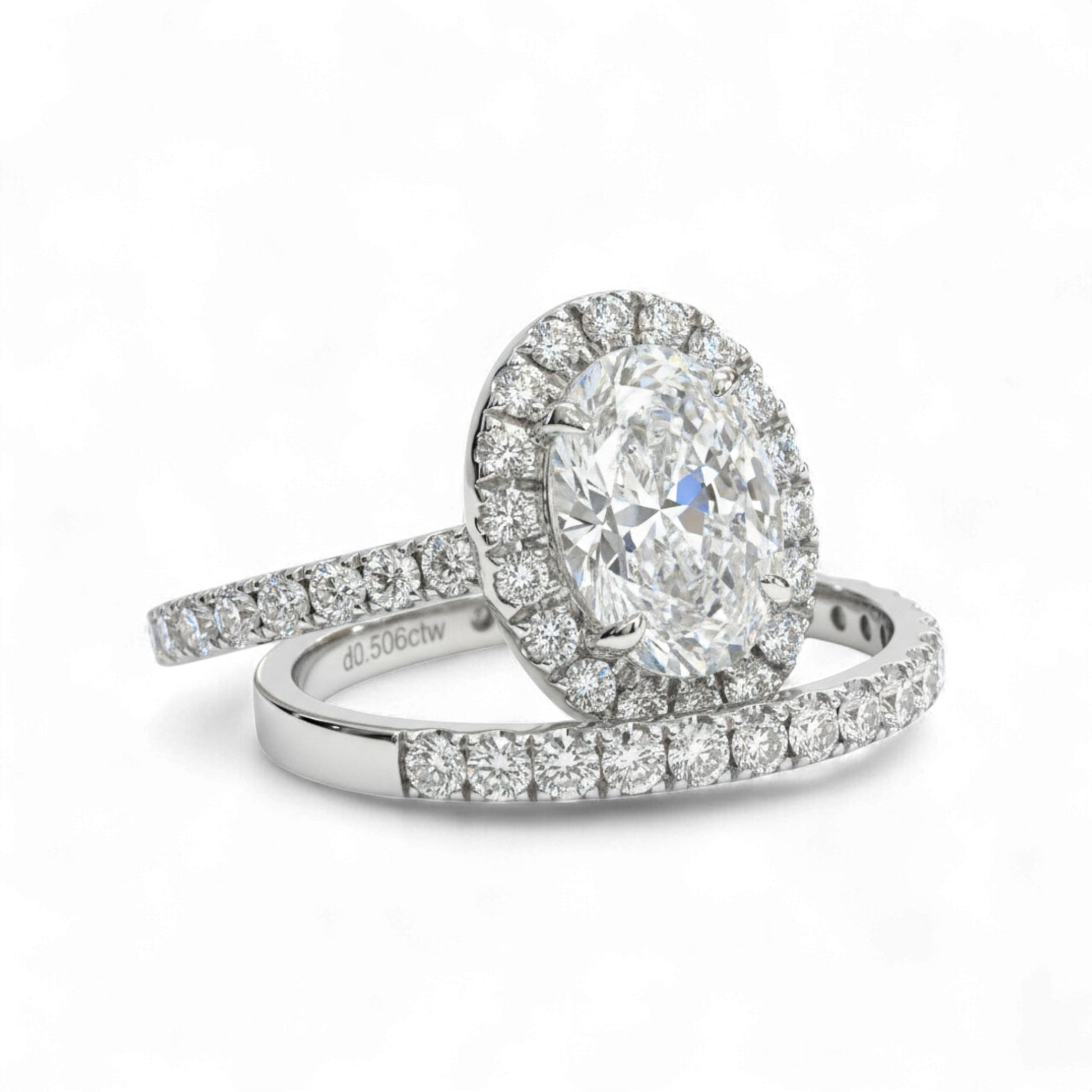 Diamond ring with a halo and smaller diamonds on a white background