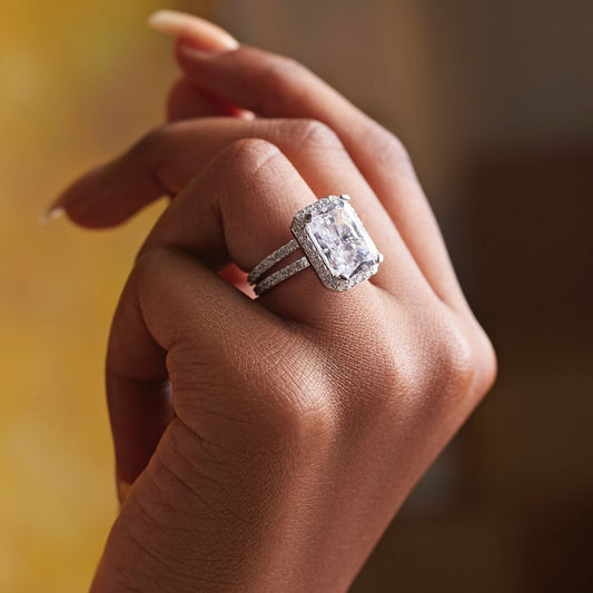 Close-up of a hand wearing a diamond ring with a blurred background