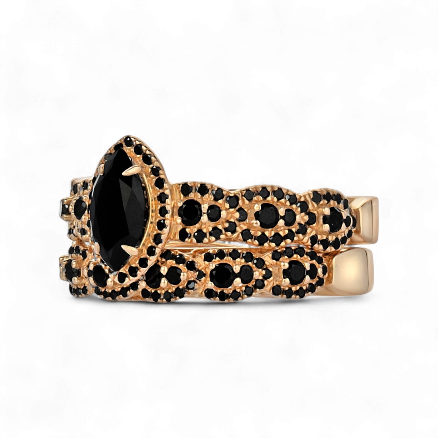 Gold ring with black gemstones on a white background