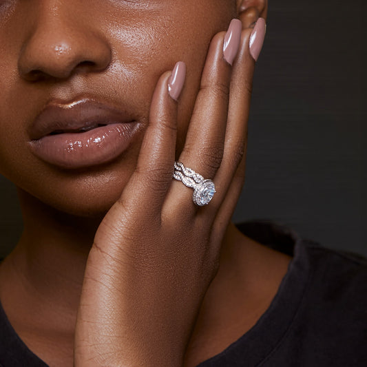 Close-up of a woman's hand wearing a diamond ring with a dark background