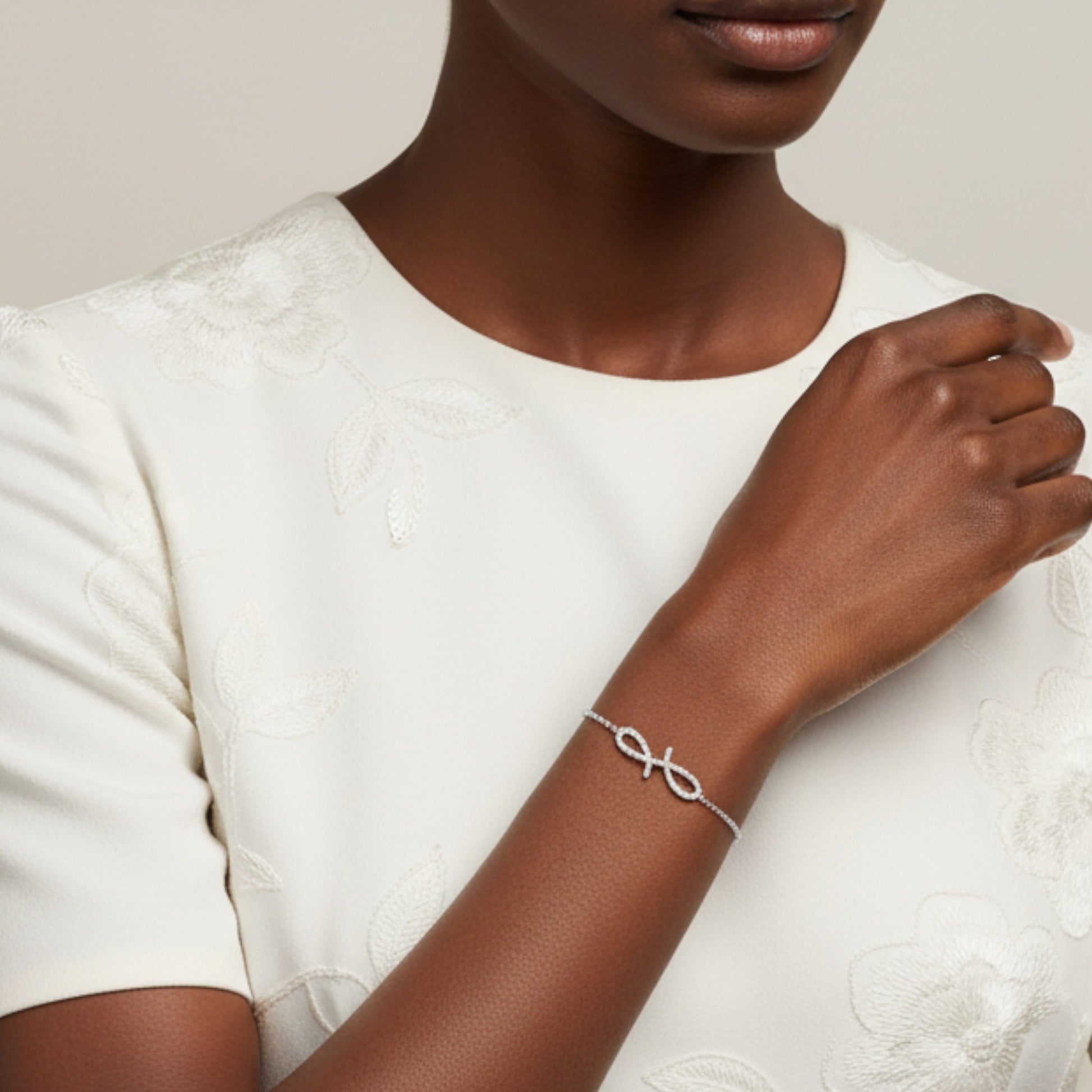 Woman wearing a silver bracelet on a neutral background