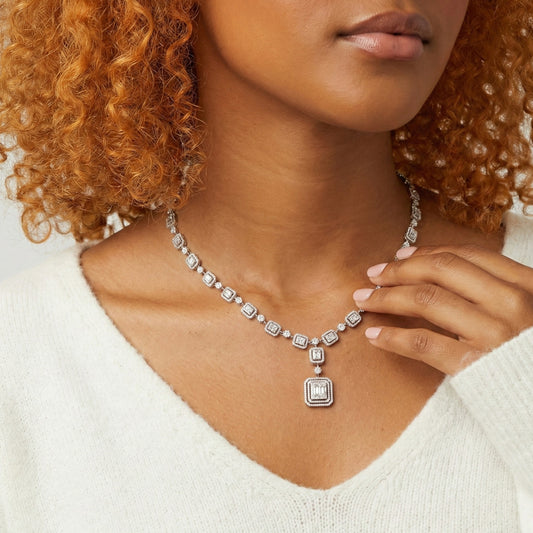 Woman wearing a diamond necklace with a white sweater