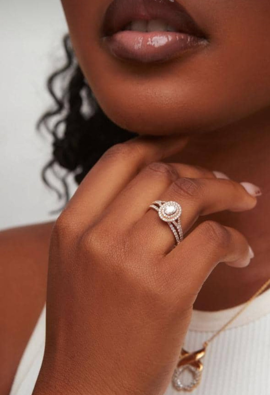 Close-up of a hand wearing a ring with a pearl on a blurred background