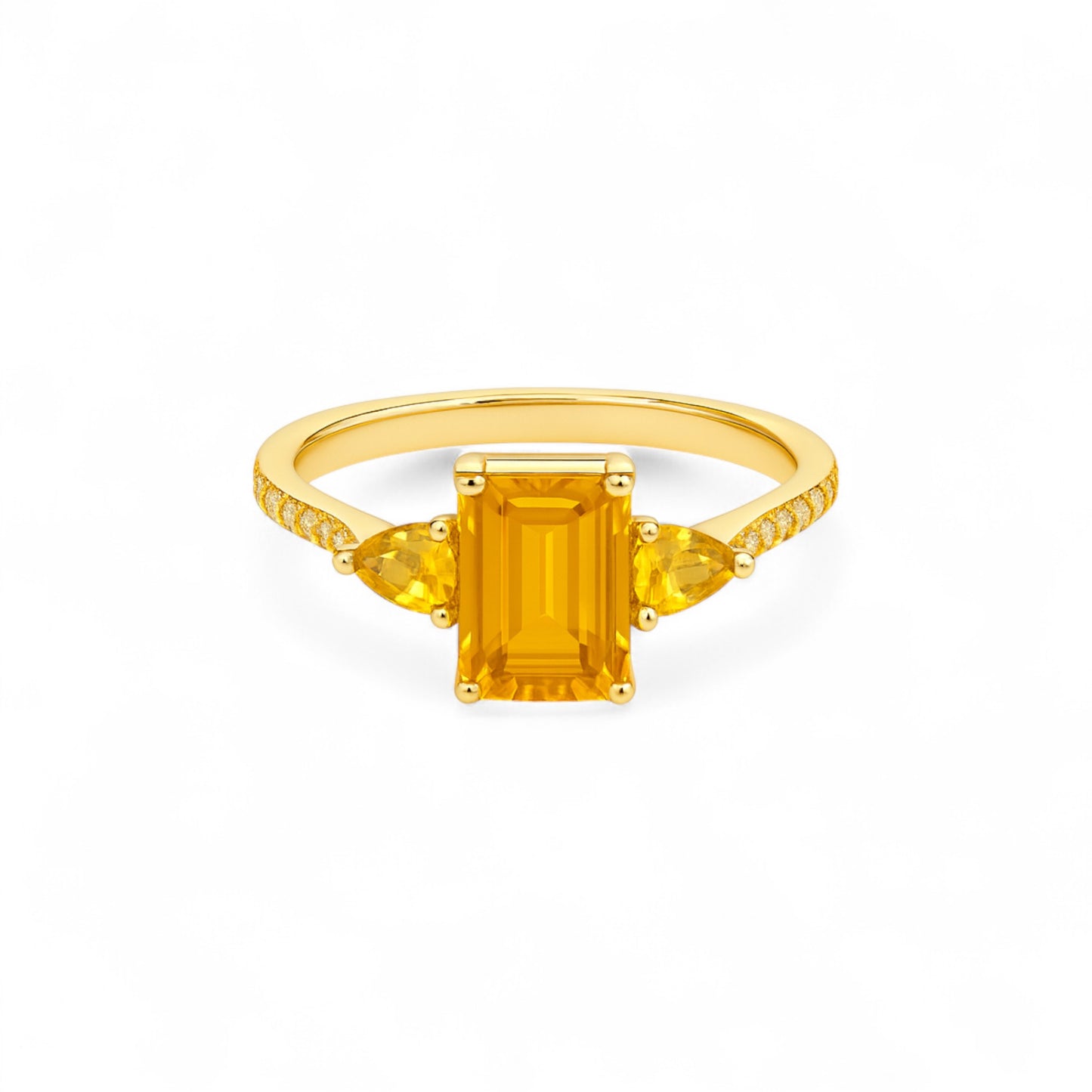 Gold ring with a rectangular yellow gemstone on a white background