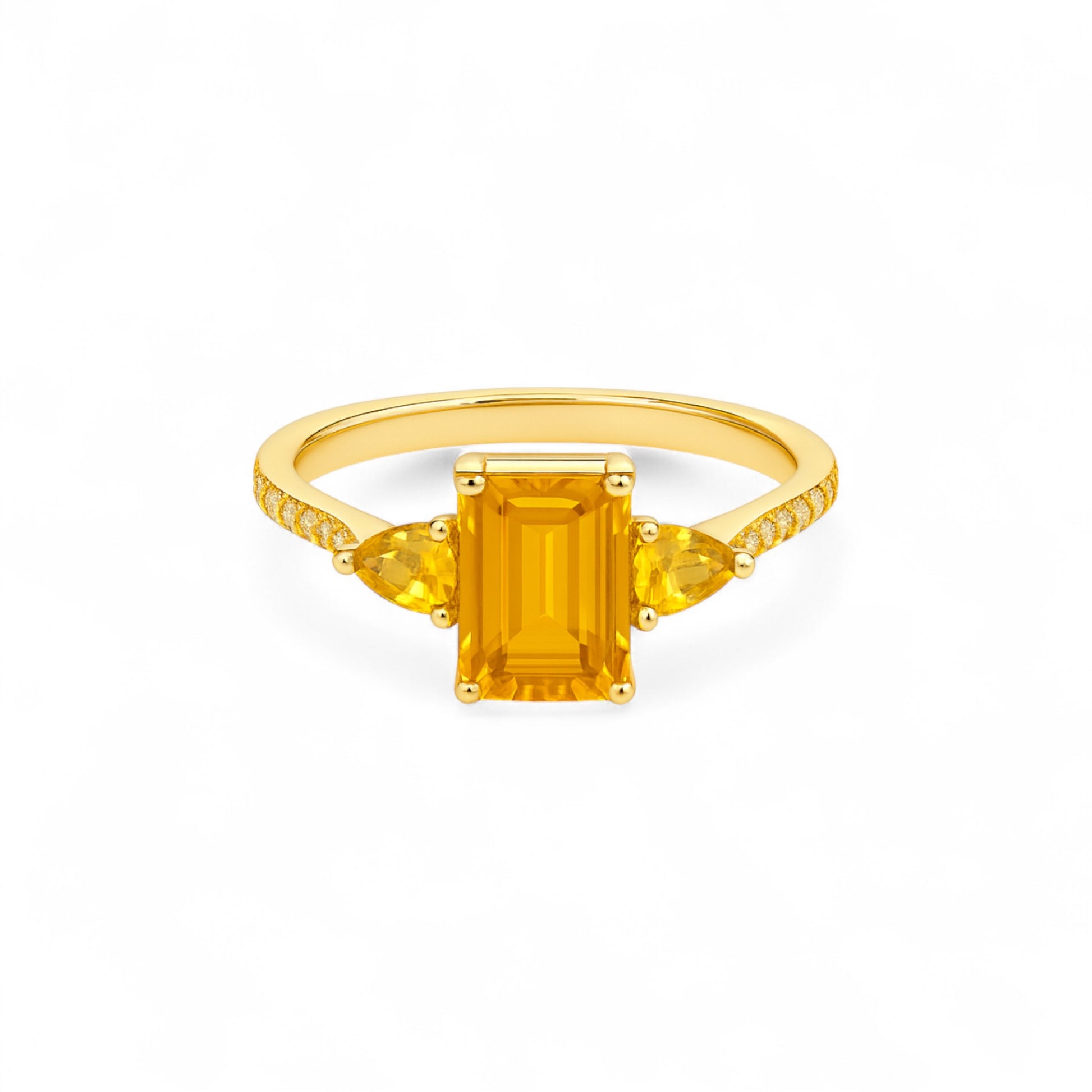 Gold ring with a rectangular yellow gemstone on a white background
