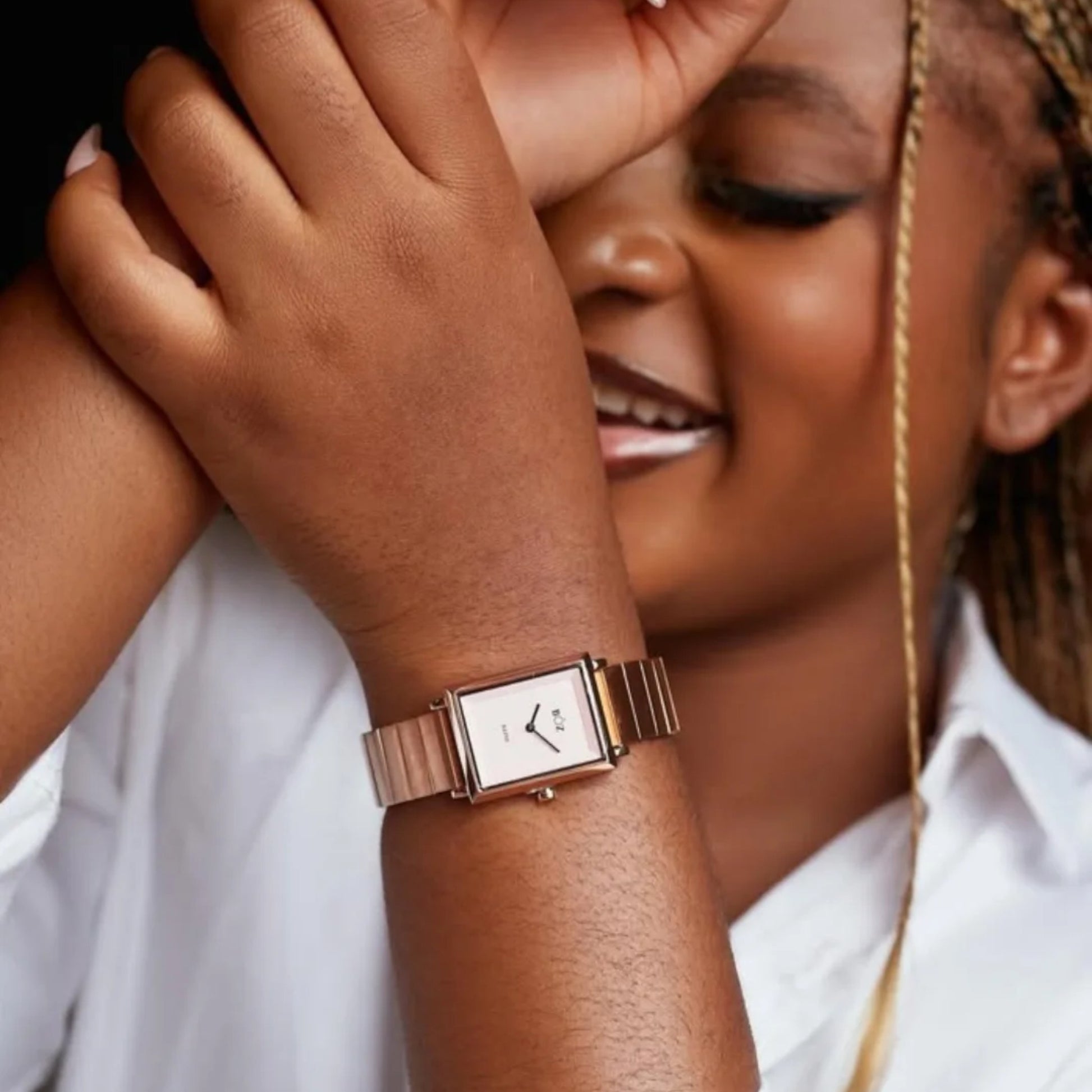 Woman wearing a rose gold watch with a blurred background