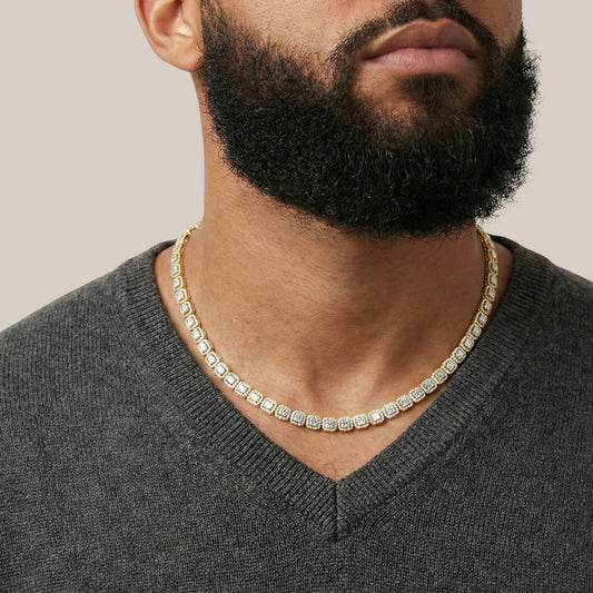 Man wearing a gold chain necklace against a neutral background