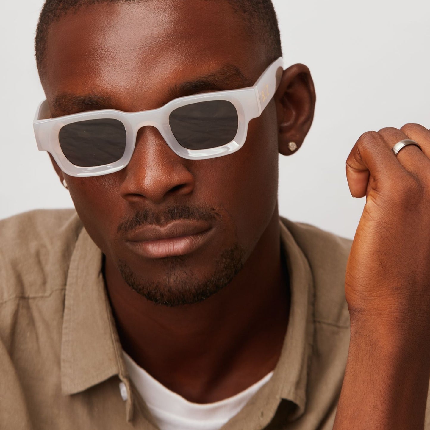 Man wearing white sunglasses with a neutral background