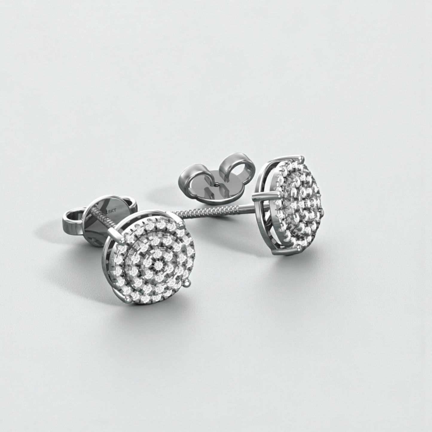 Pair of silver earrings with clear gemstones on a light gray background