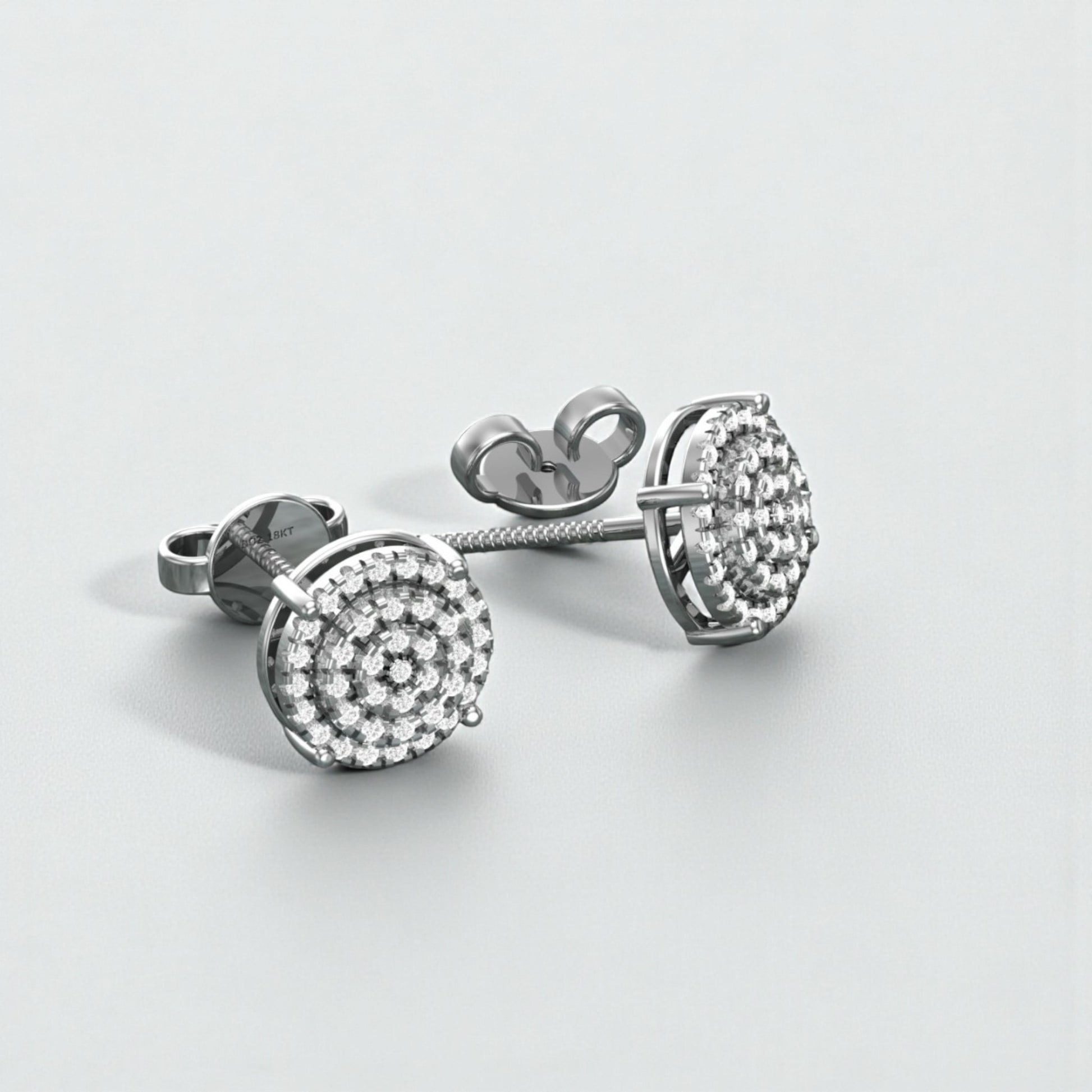 Pair of silver earrings with clear gemstones on a light gray background