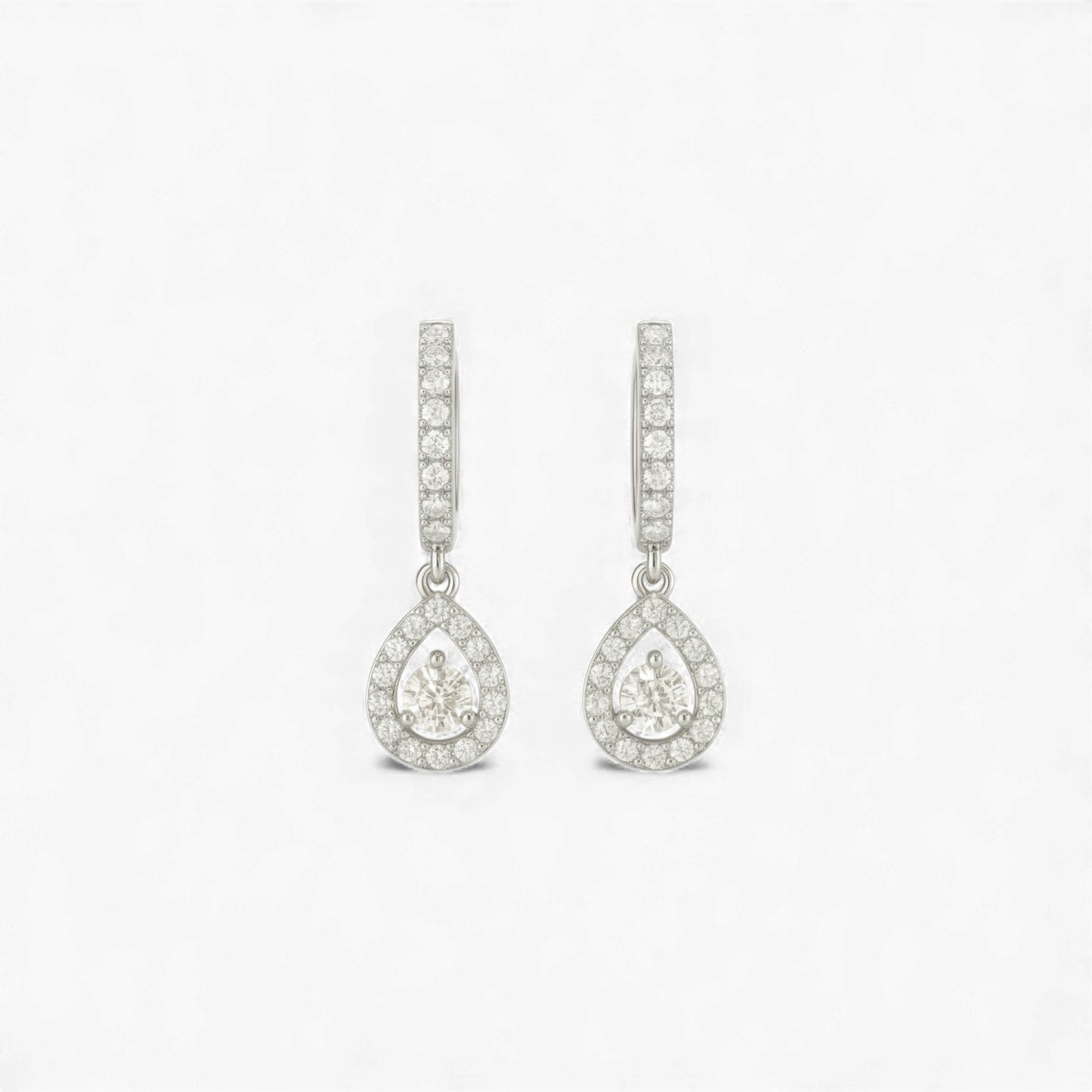 Teardrop-shaped earrings with clear gemstones on a light gray background