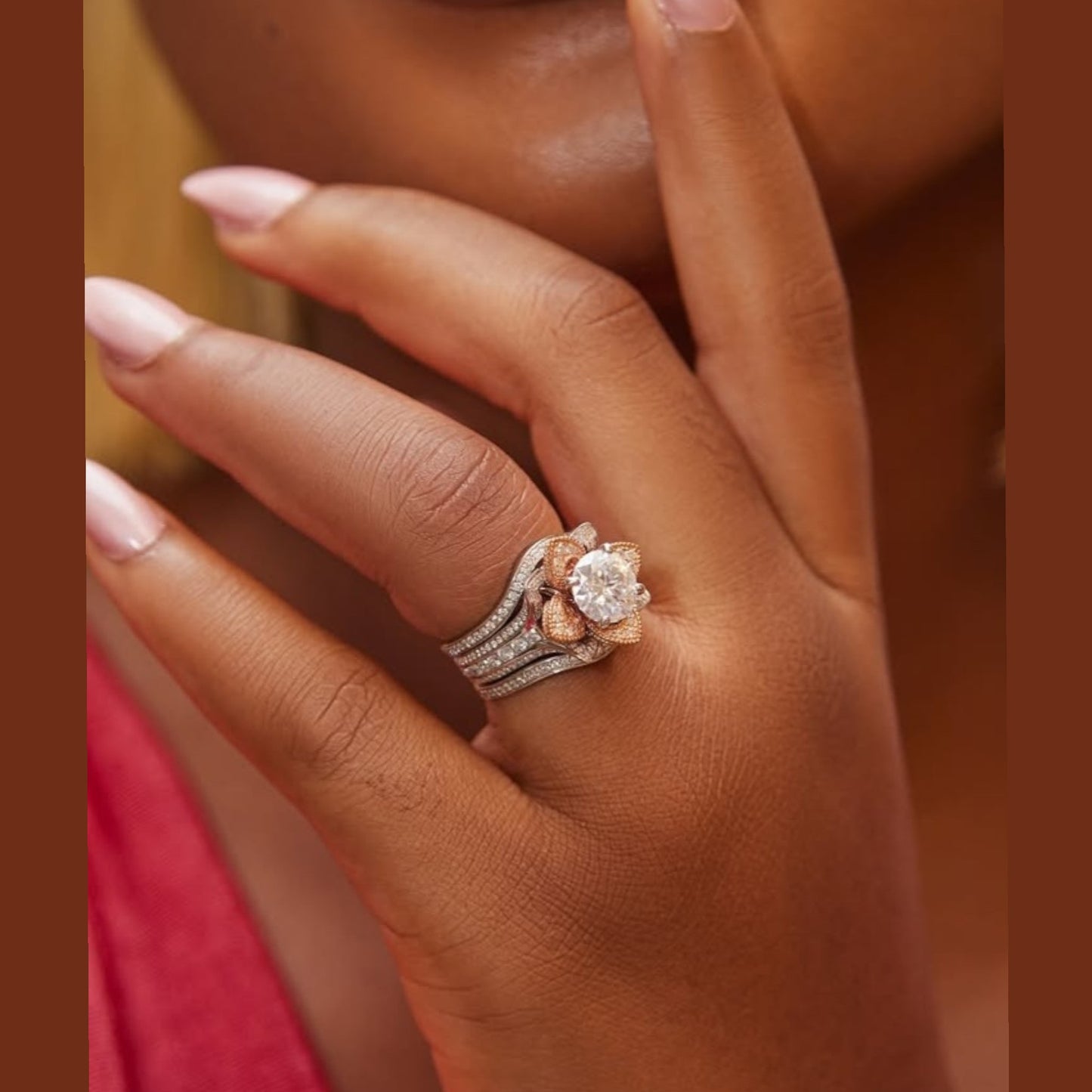 Close-up of a hand wearing two diamond rings on a brown background