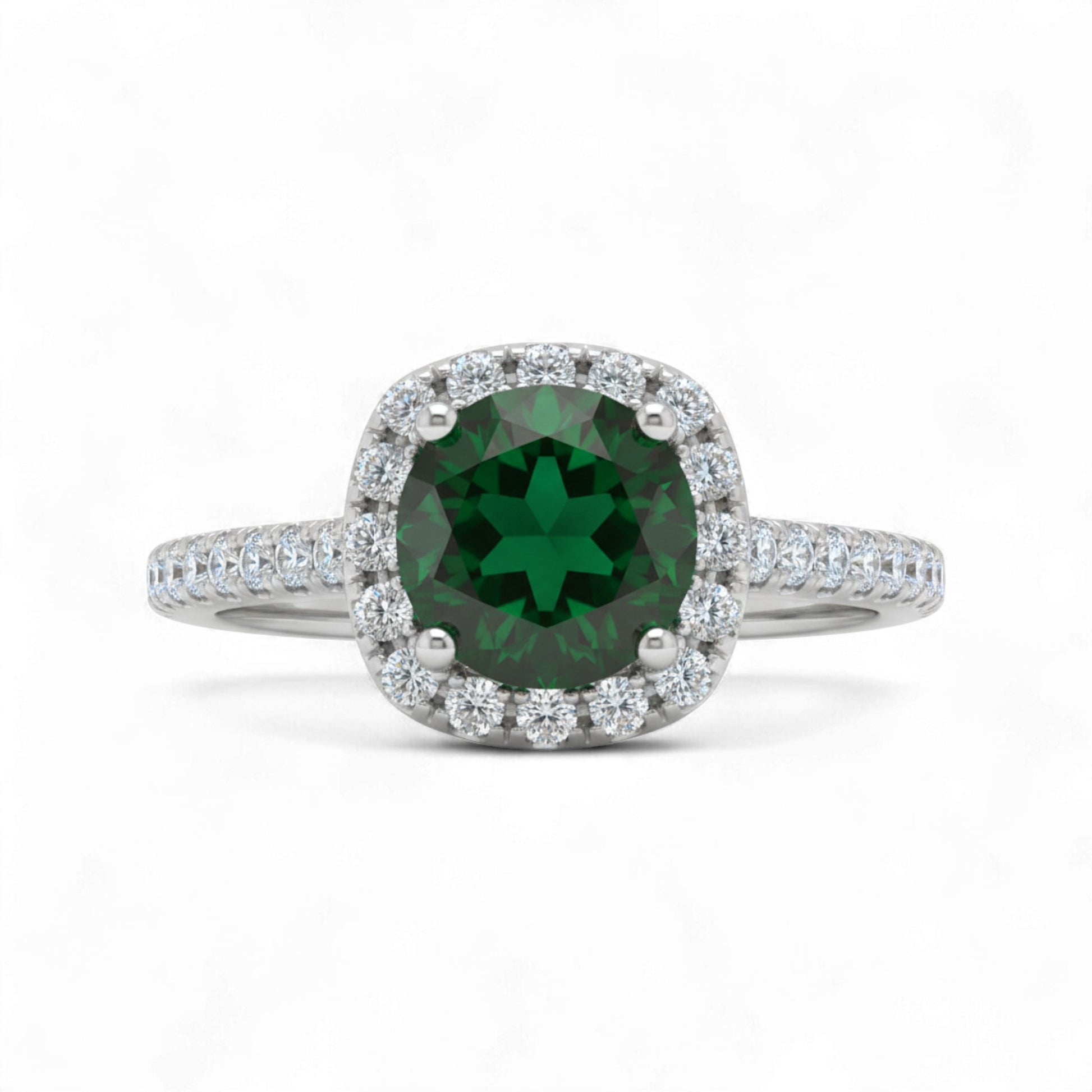 Ring with a green gemstone and diamond halo on a white background