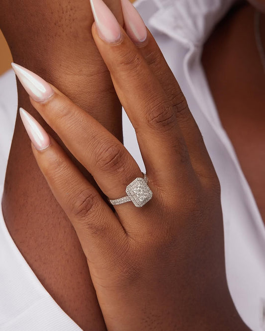 A person's hand displaying a radiant cut natural diamond engagement ring on a white gold band.