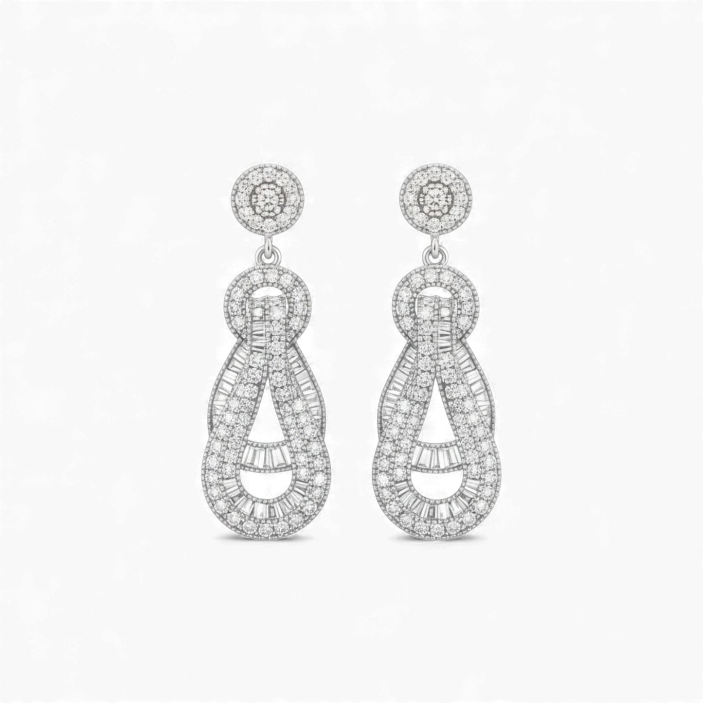 Pair of silver earrings with intricate designs on a white background