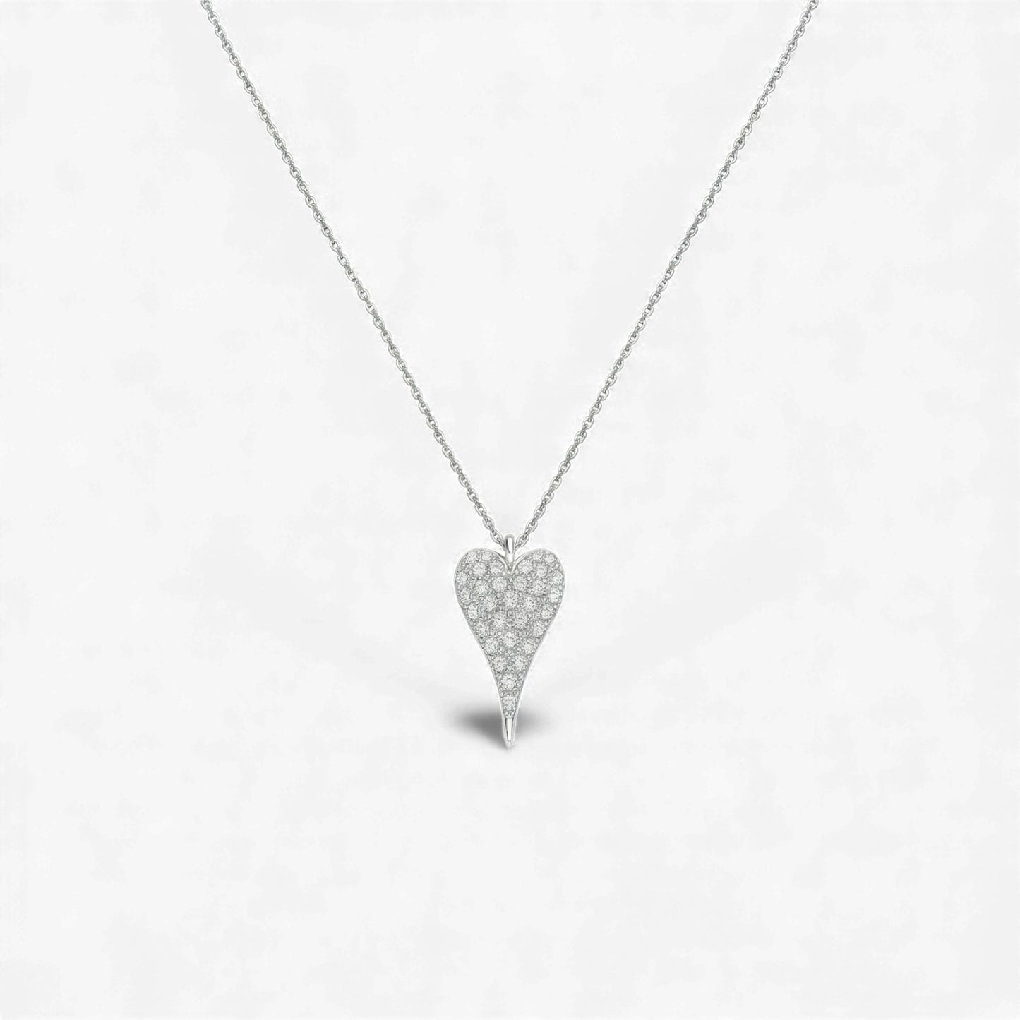 Heart-shaped diamond necklace on a light gray background
