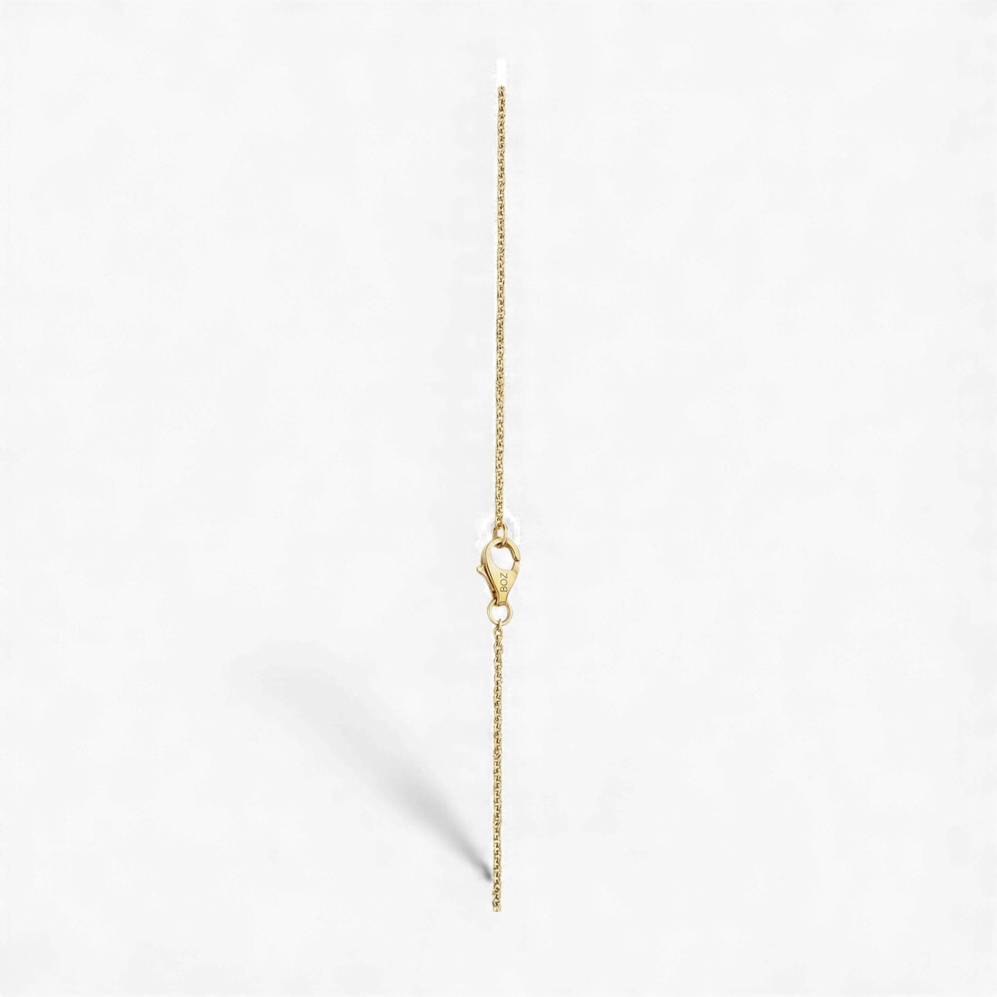 Gold chain necklace on a light gray background