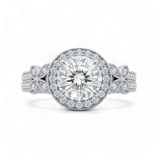 Silver ring with a large diamond and smaller diamonds on the band against a white background