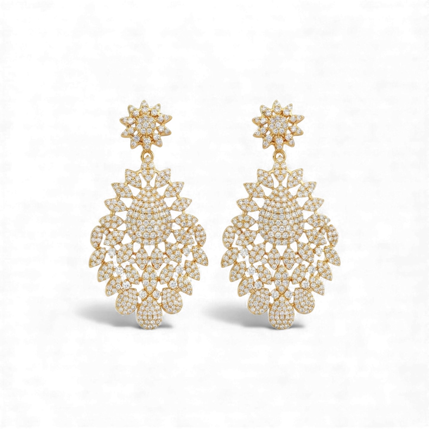Pair of gold earrings with intricate designs on a white background