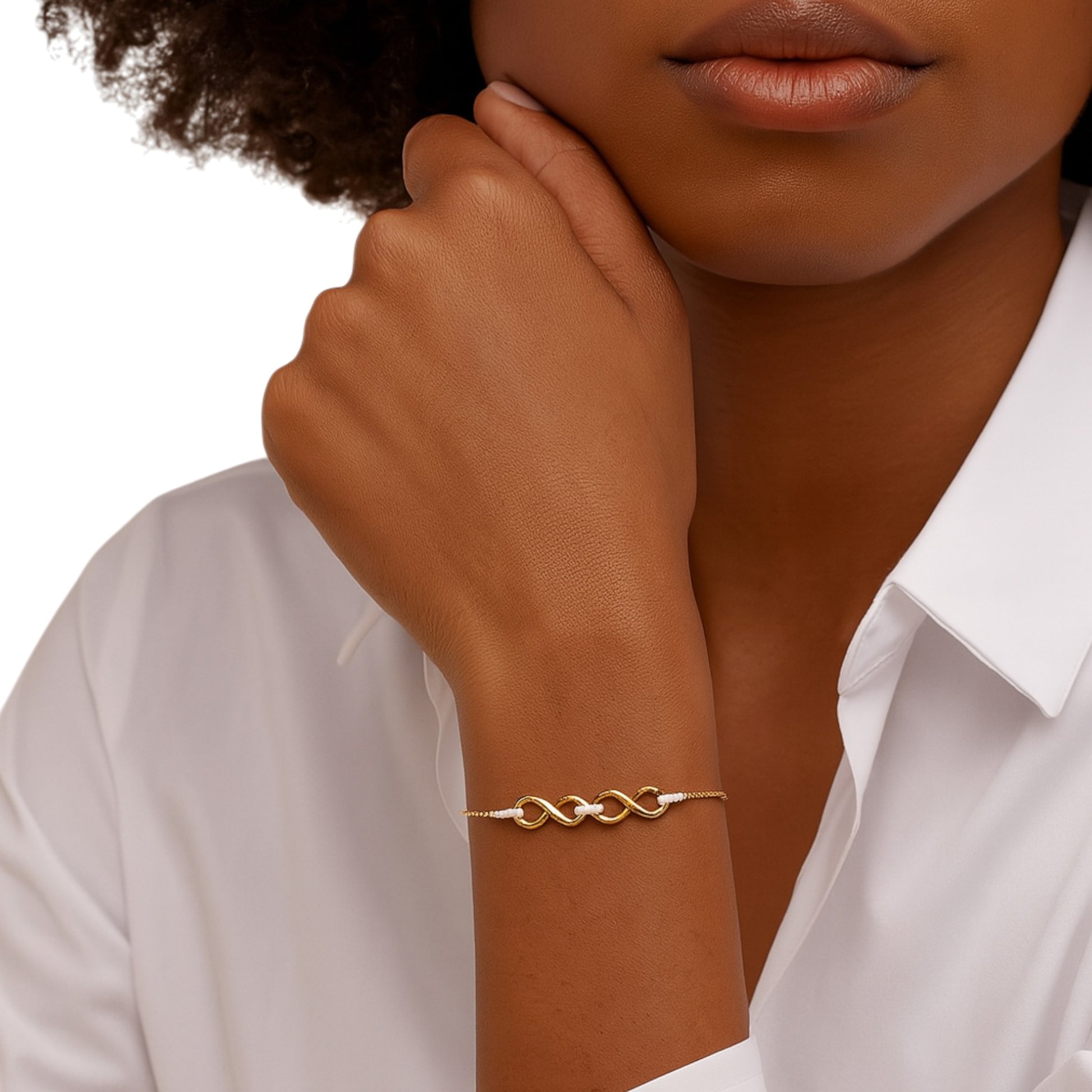 Gold bracelet on a wrist with a white shirt background
