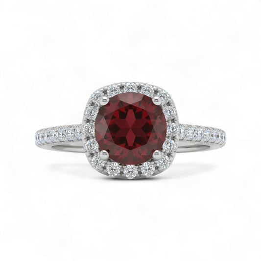 Ring with a red gemstone and diamond accents on a white background