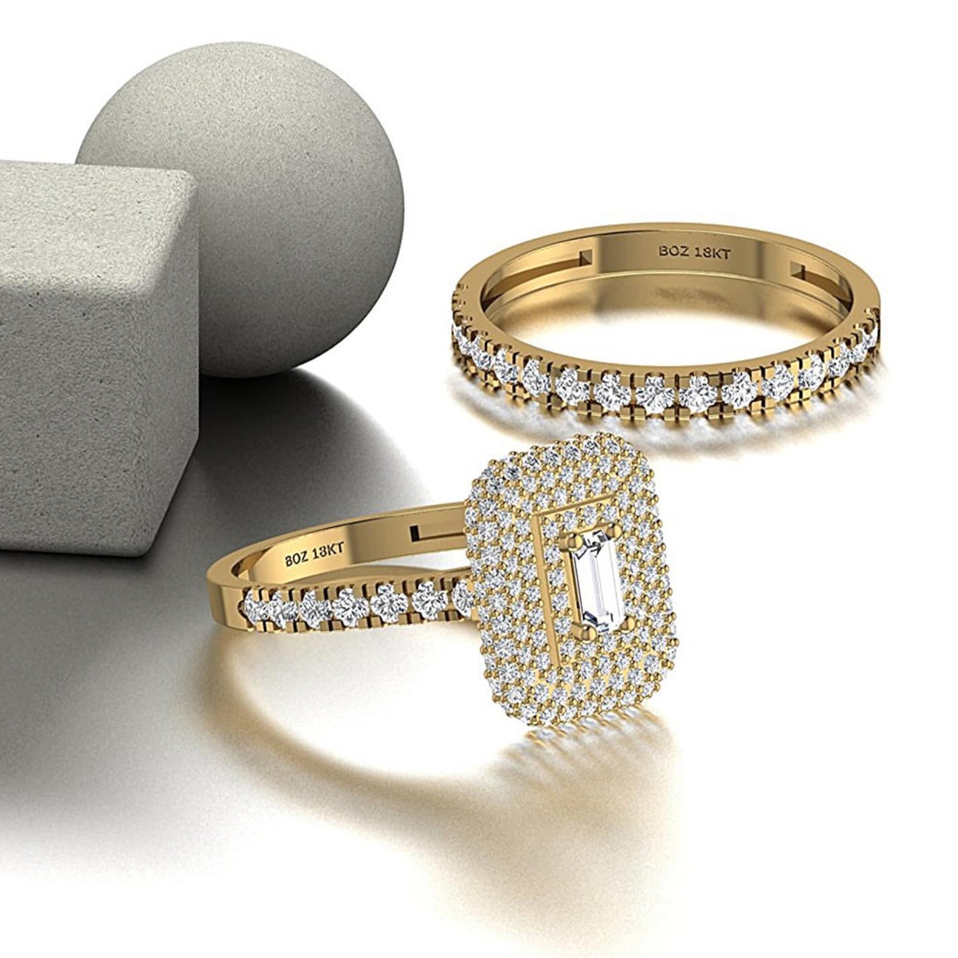 Two gold rings with diamond accents on a light background