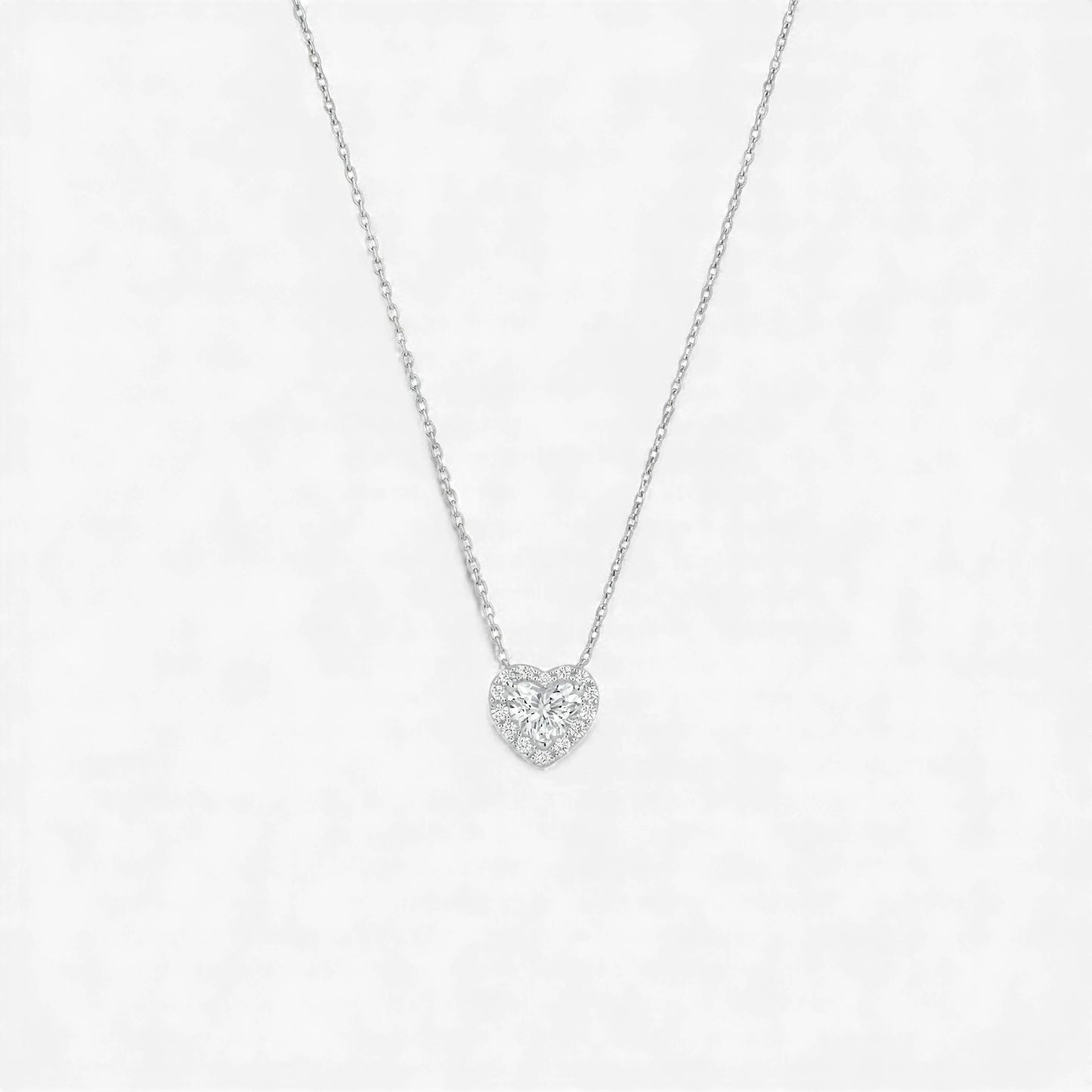 Heart-shaped diamond necklace on a light gray background