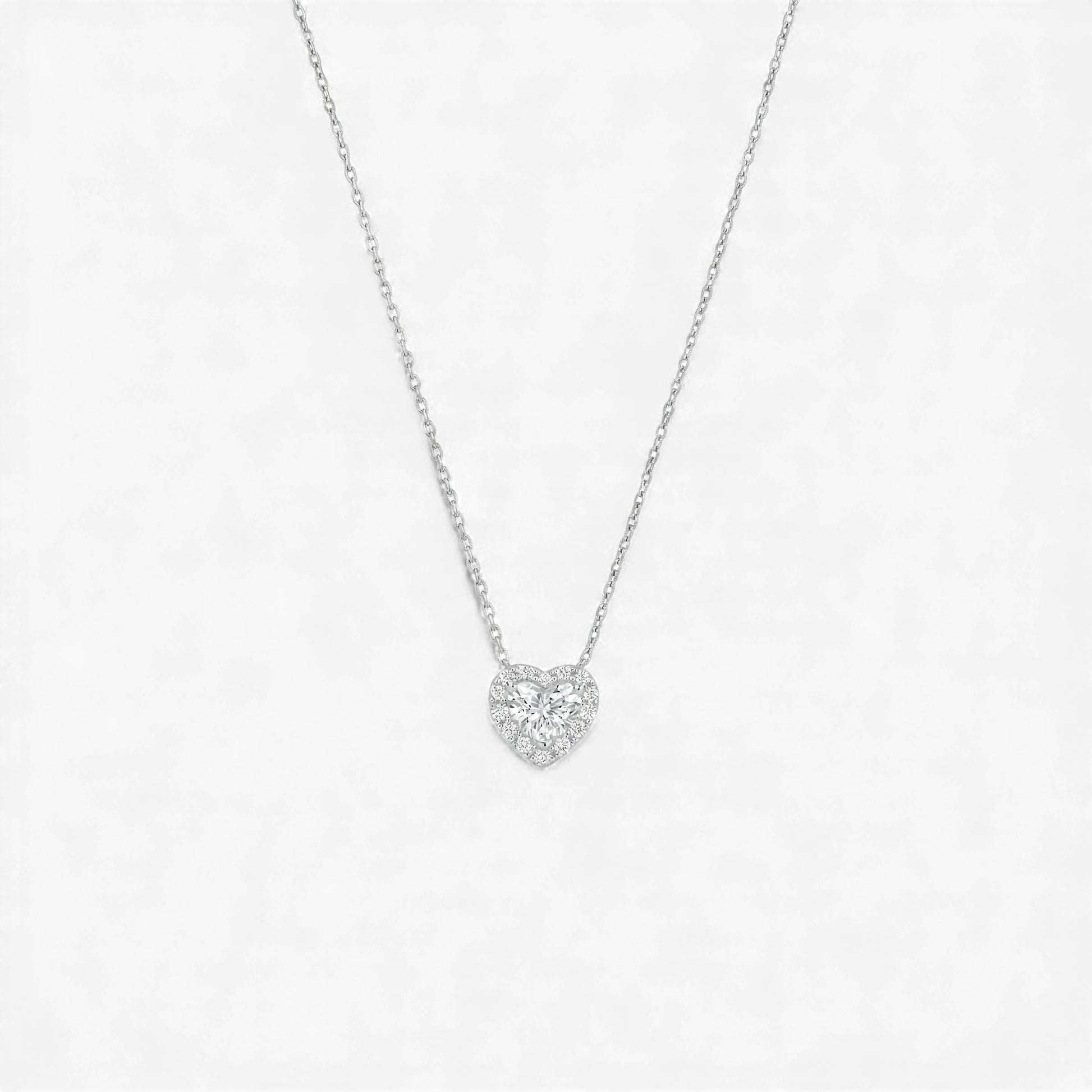 Heart-shaped diamond necklace on a light gray background