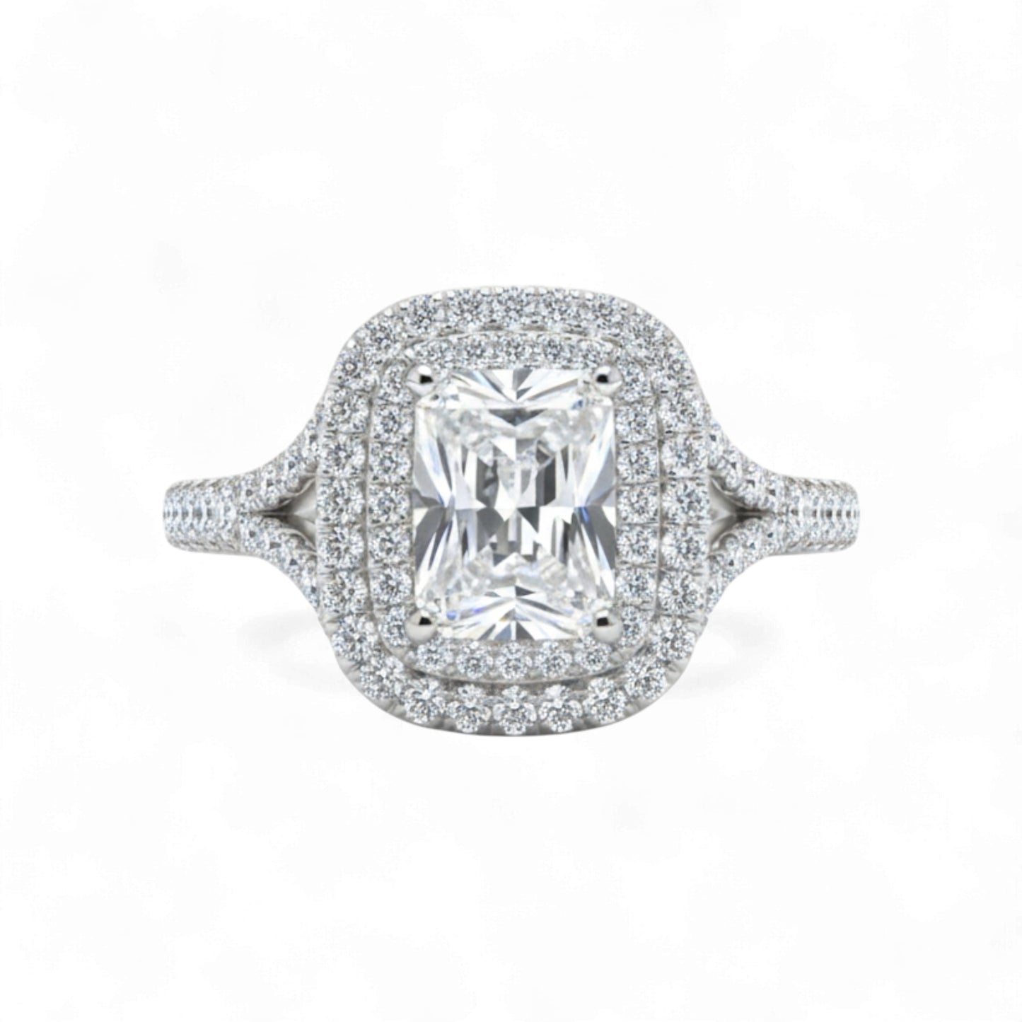 Diamond ring with a central gemstone and halo on a white background