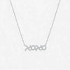 Silver necklace with 'xoxo' pendant on a light gray background